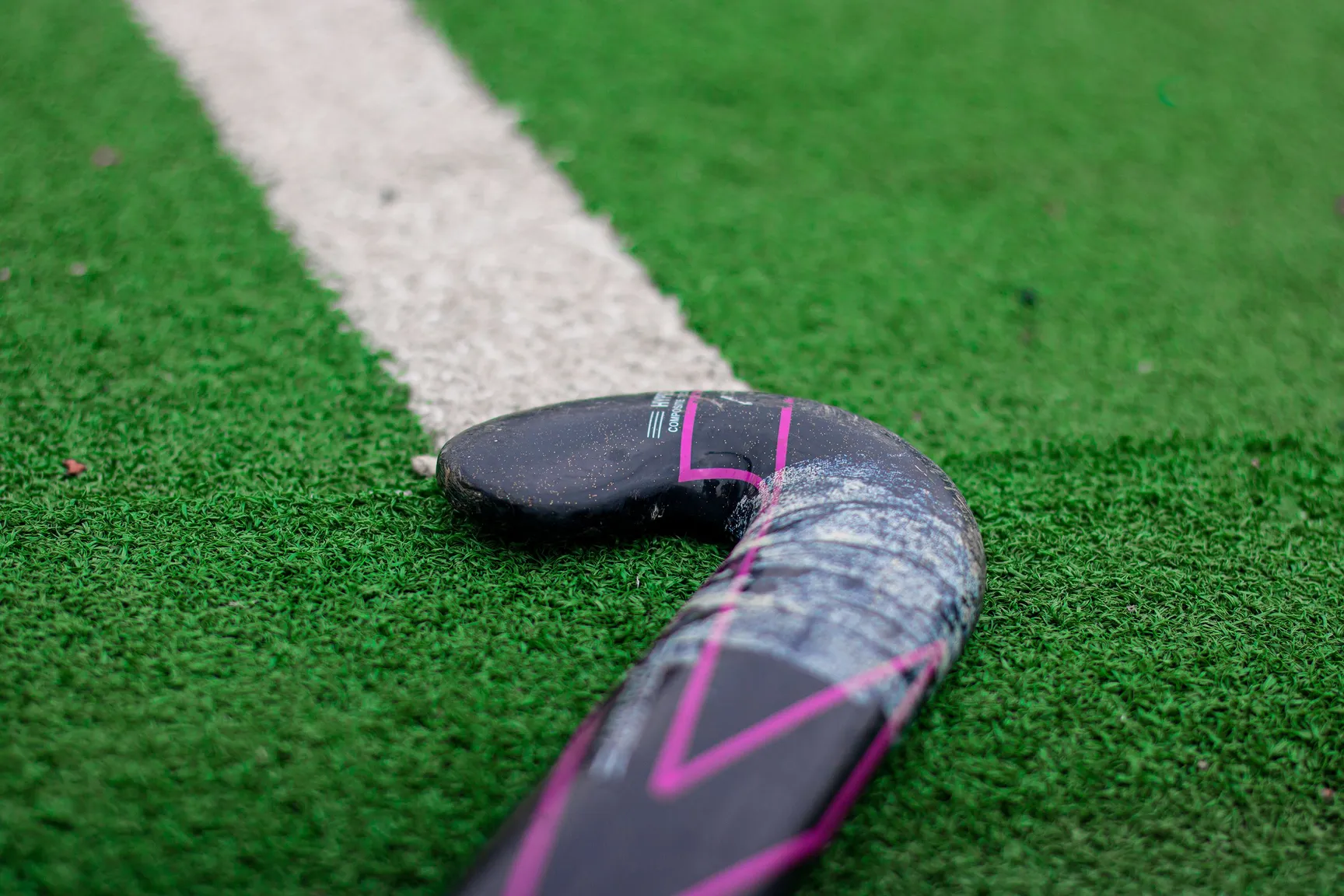 Hockeyschläger auf dem Kunstrasen an der Spielfeldlinie